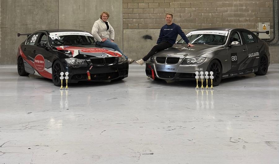 Mathijs en Remon bij hun raceauto's in de paddock